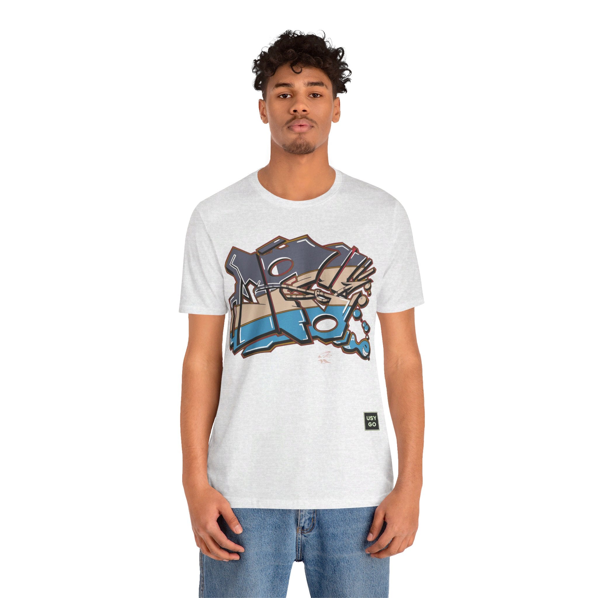 Person wearing Bella+Canvas 3001 Unisex Jersey Short Sleeve Tee with JG Fish Graffiti design on the front. Made from lightweight 100% Airlume combed and ring-spun cotton in Ash, ideal for active and leisure wear.