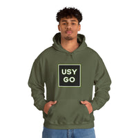 Person wearing a Heavy Blend Hoodie Gildan 18500 Unisex Jersey with big USYGO logo on the front. Made from 50% Cotton 50% Polyester in Military Green. Pouch pocket and the tear-away label make for a highly comfortable, scratch-free wearing.