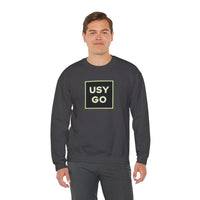 Person wearing a Heavy Blend Crewneck Sweatshirt Gildan 18000 Unisex with USYGO logo on the front. Made from 50% Cotton 50% Polyester in Dark Heather.