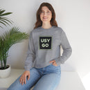 Person wearing a Heavy Blend Crewneck Sweatshirt Gildan 18000 Unisex with USYGO logo on the front. Made from 50% Cotton 50% Polyester in Sport Grey.